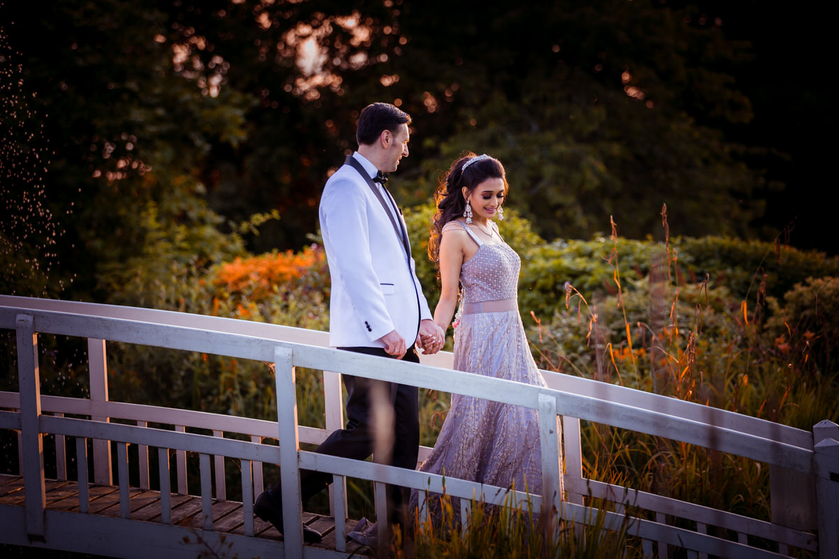 Bride and groom walking hand in hand down the bridge at fennes